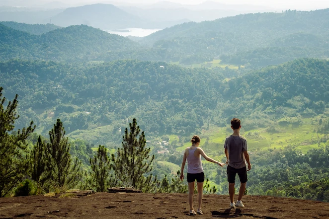 Two persons holding hands on top of a mounting