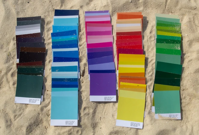 Hundred color cards with diffrent colors on the sand